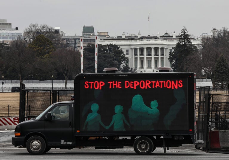 An L.E.D. truck displaying messages expressing concern over the continuing mass deportations of Black immigrants drives past the White House