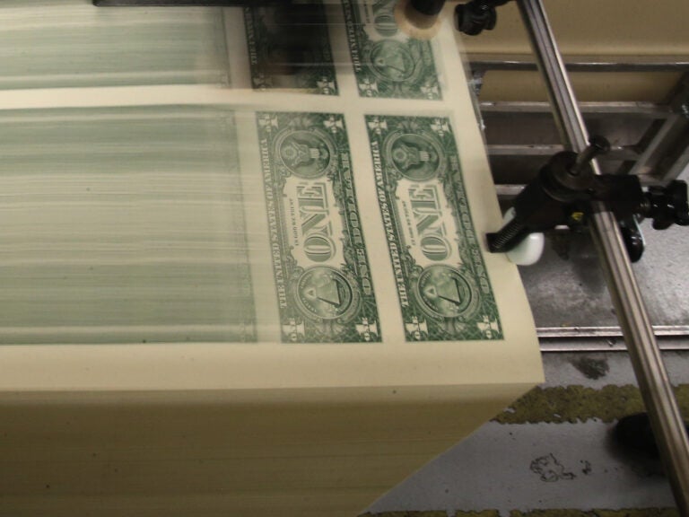 Sheets of one-dollar bills run through the printing press at the Bureau of Engraving and Printing in 2015 in Washington, D.C. Congressional forecasters projected the federal deficit this fiscal year will hit its highest since World War II. (Mark Wilson/Getty Images)