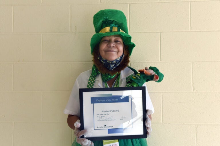 On January 27 at the COVID-19 vaccination center at Camden County College in Blackwood, NJ, Marisol Rivera shows off the Prichard Industries Employee of the Month certificate she's just been awarded. (April Saul for WHYY)