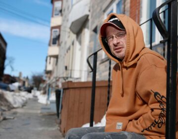 Michael Salemno sits on a stoop outside