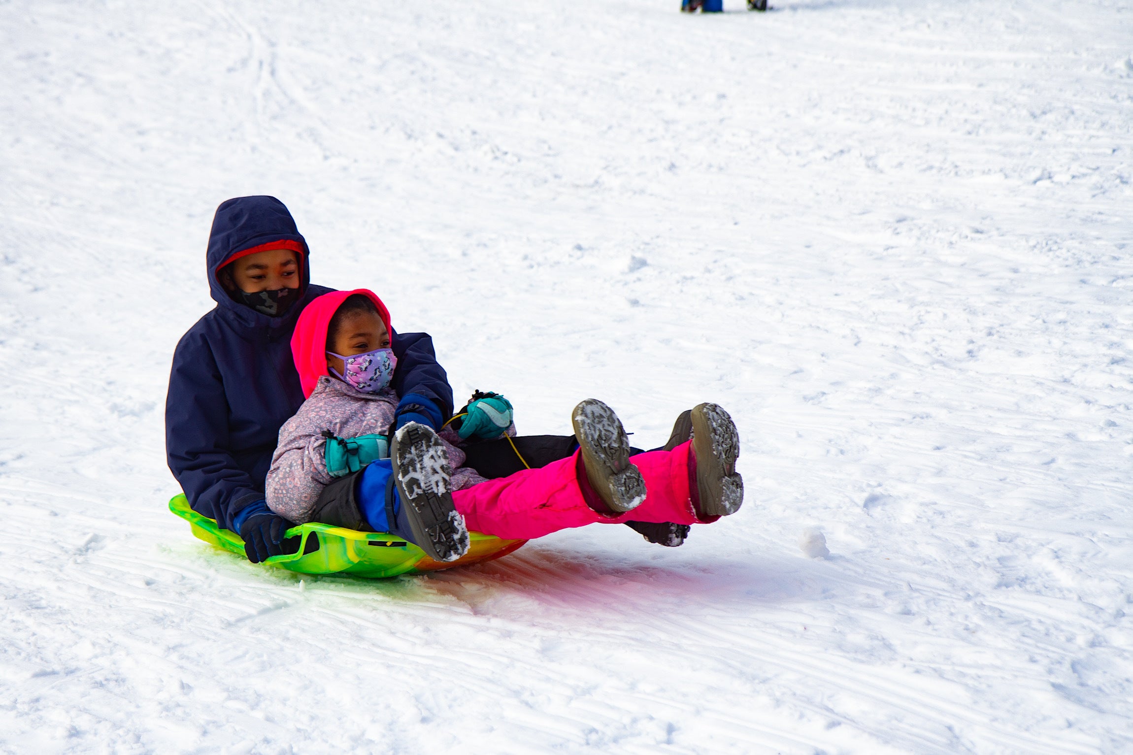 Two happy sledders skid down the dome at Clark Park in West Philadelphia.