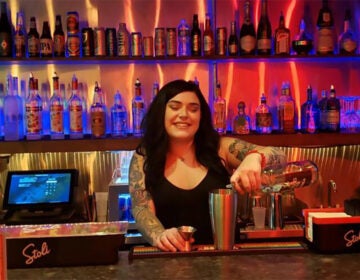 A bartender pours a drink at the Toasted Walnut