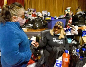 On March 5, 2021, at her warming center in the Yorkship Family School gym, Tawanda Jones, right, tries to convince a patron known as Sarah Ann to allow Jones to help her rent a room at a boarding house. Sarah Ann had told Jones that if there was nowhere else to go that night, she would sleep in Camden's Evergreen Cemetery.  (Photo by April Saul for WHYY)