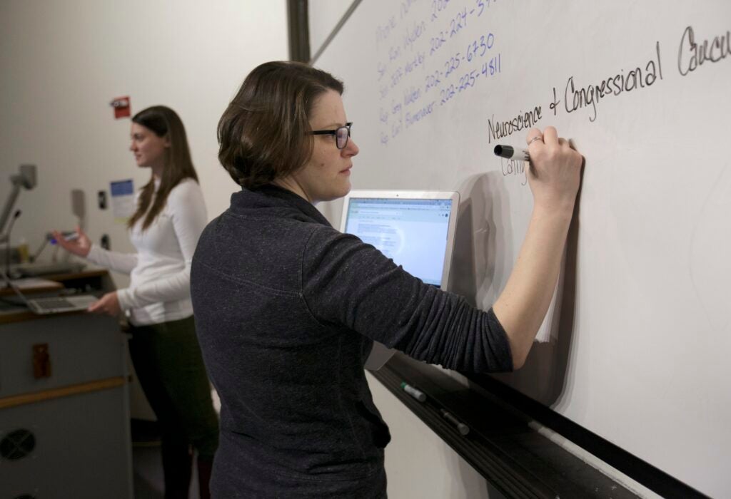 OHSU School of Medicine student Mollie Marr writes in front of a whiteboard. She helps organize a letter-writing campaign for students to share personal stories about the impact of losing a proposed tax waiver for tuition for graduate students, December 1, 2017. Marr is pursuing her M.D. and her Ph.D. in behavioral neuroscience in the OHSU School of Medicine, and losing the tax waiver could mean dropping out of OHSU. 