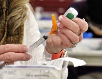 Registered nurse Pat DeHorsey draws a dose of COVID-19 vaccine