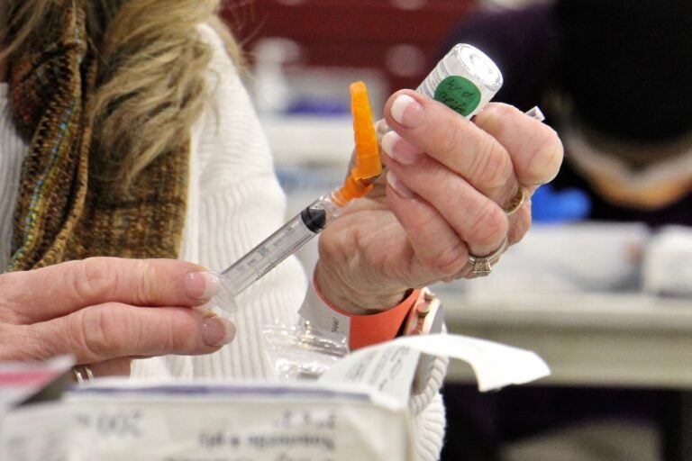 Registered nurse Pat DeHorsey draws a dose of COVID-19 vaccine