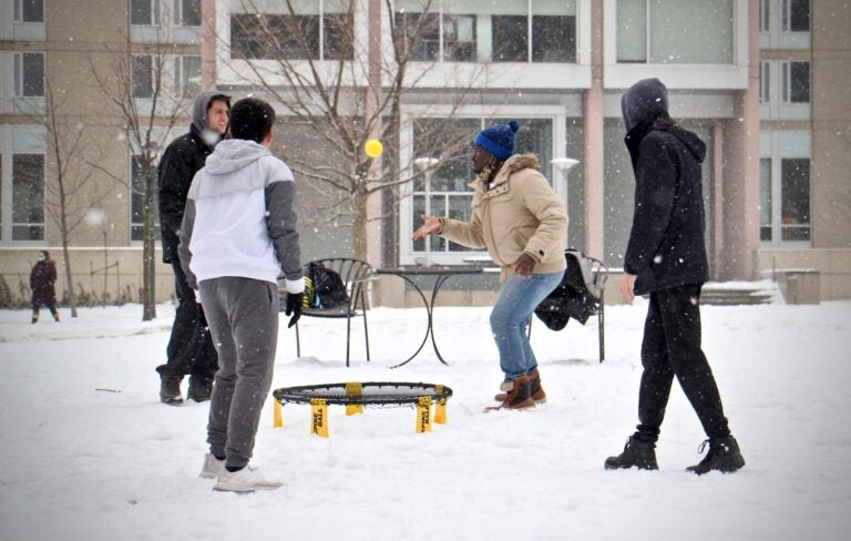 University of Pennsylvania students play a game on a snowy quad. (Emma Lee/WHYY)