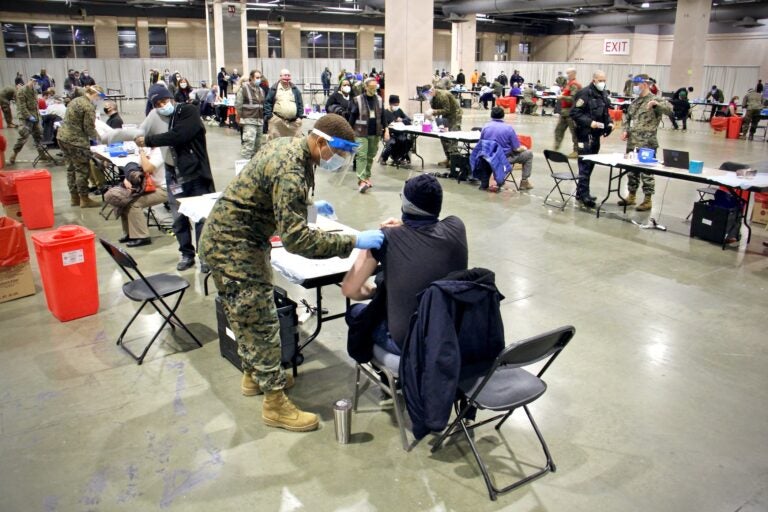 A National Guard member vaccinates someone against COVID-19 at the Pennsylvania Convention Center