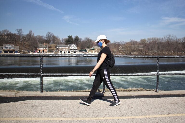 Maria Becker Gallagher strolls past the Schuylkill River on Martin Luther King Drive on March 11, 2021. (Emma Lee/WHYY)