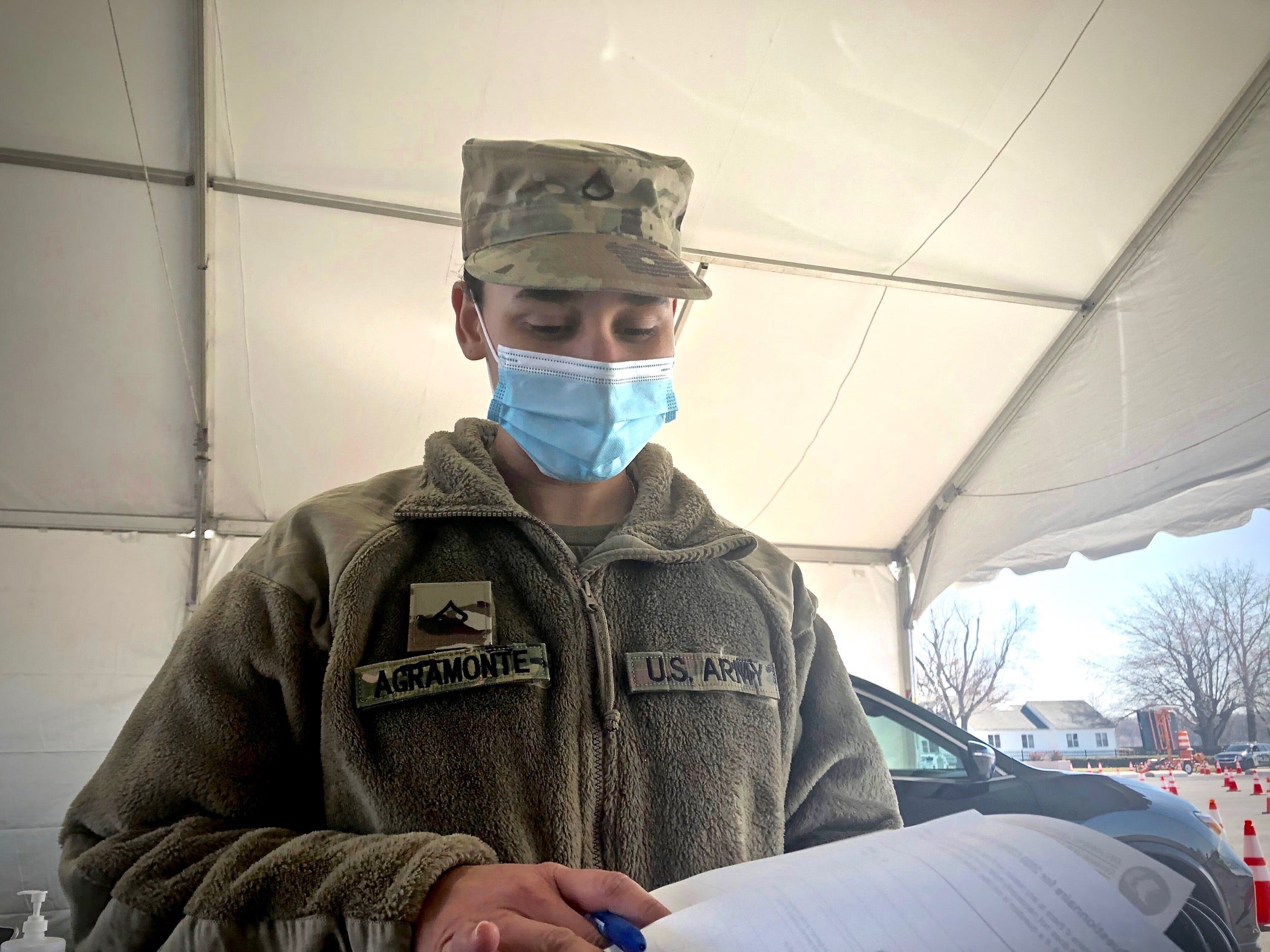 Pfc. Cynthia Agramonte inspects paperwork at a checkpoint