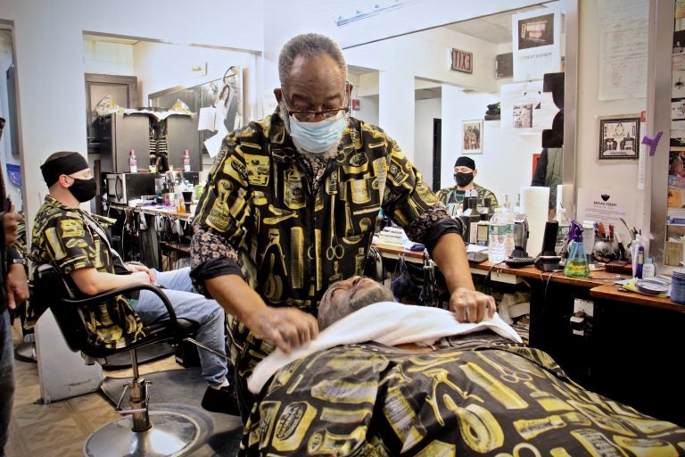 Leroy Robinson Jr. tends to a customer at Leroy's Barbershop on Lancaster Avenue. (Emma Lee/WHYY)
