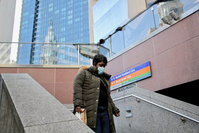 A rider descends the stairs to the 15th Street subway station, across the street from City Hall. (Emma Lee/WHYY)