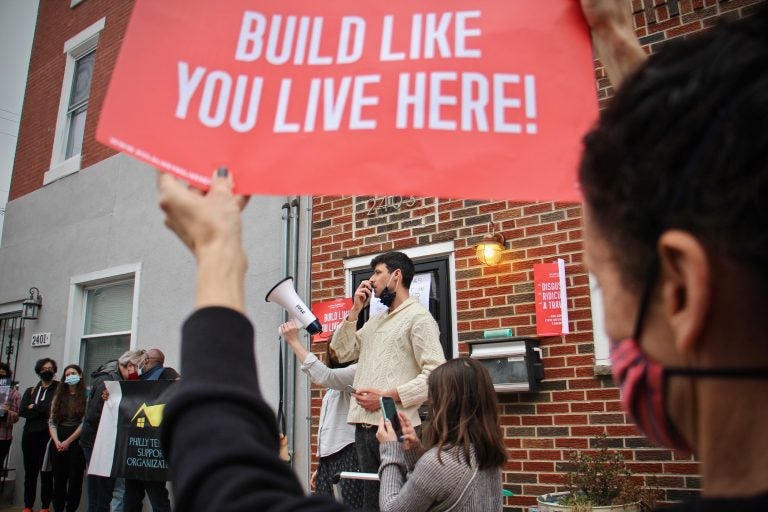 Adrian Bondy, a leader of the Build Like You Live Here neighborhood organization, speaks to protesters during a rally at 2400 East Huntingdon Street. A seven-story building is planned for that address in a neighborhood of two- and three-story rowhouses. (Emma Lee/WHYY)