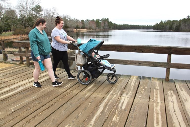 Maegan Nelson (right) and her cousin, Sarah Nargi, stroll along Batsto Lake in Wharton State Forrest with Nargi's daughter, Paisley.
