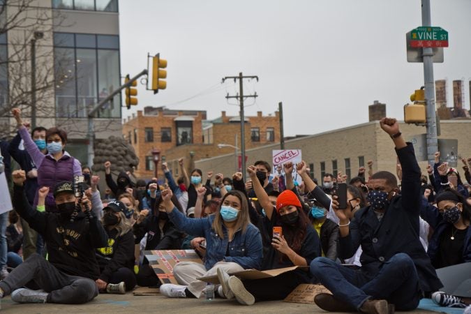 Participants at a solidarity rally at 10th and Vine streets raised fists against white supremacy and violence against their communities on March 25, 2021. (Kimberly Paynter/WHYY)