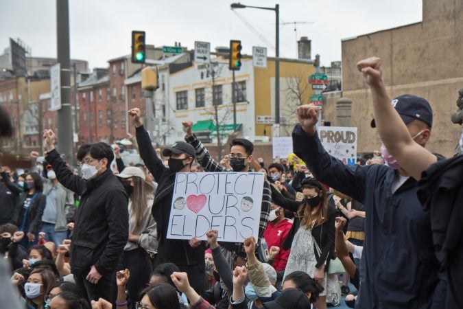 Participants at a solidarity rally at 10th and Vine streets raised fists against white supremacy and violence against their communities on March 25, 2021. (Kimberly Paynter/WHYY)
