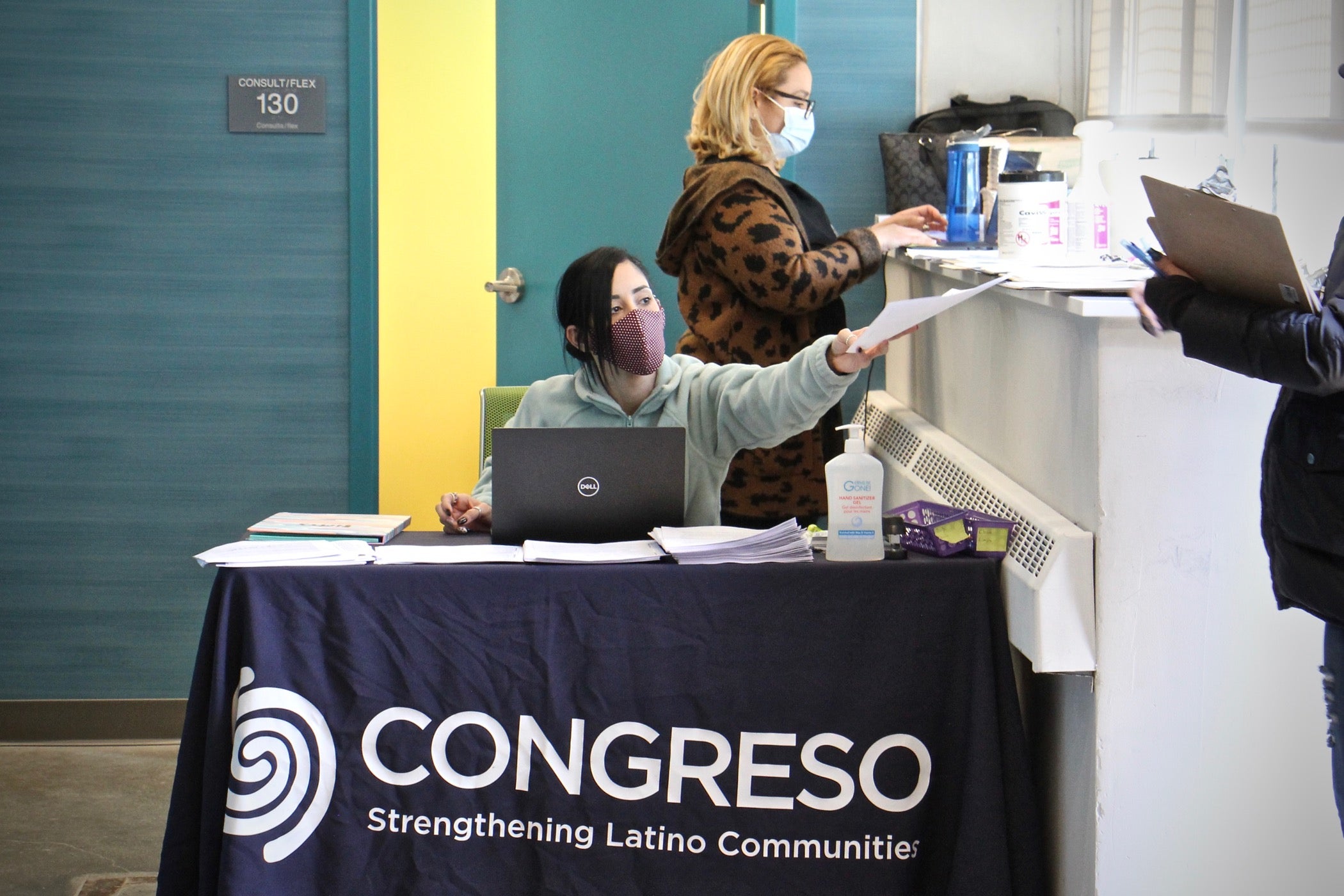 Medical assistants Yeishaliz Cruz (seated) and Luz Vasquez welcome patients to Congreso's COVID-19 vaccination clinic