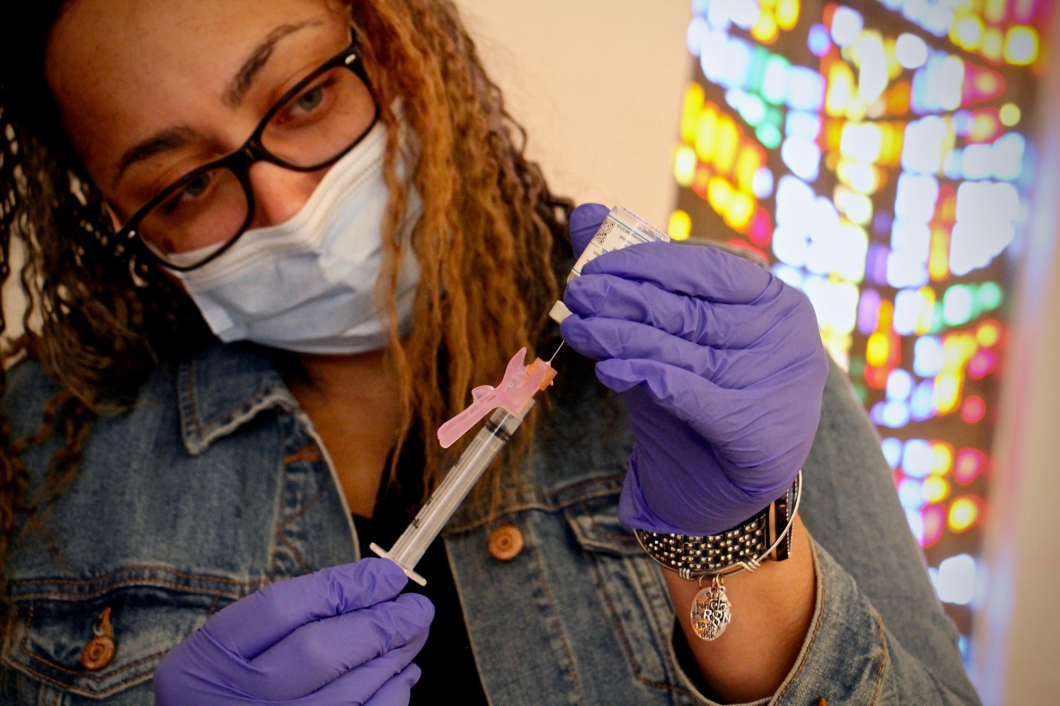 Registered nurse Elizabeth Lash prepares doses of COVID-19 vaccine