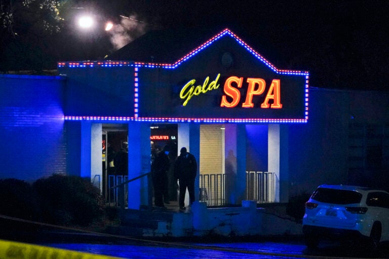 Officials in front of in a massage parlor shooting on Tuesday, March 16, 2021, in Atlanta. Several people were killed and others injured at a massage parlor in Cherokee County, and Atlanta Tuesday, March 16, 2021, officials said. (AP Photo/Brynn Anderson)
