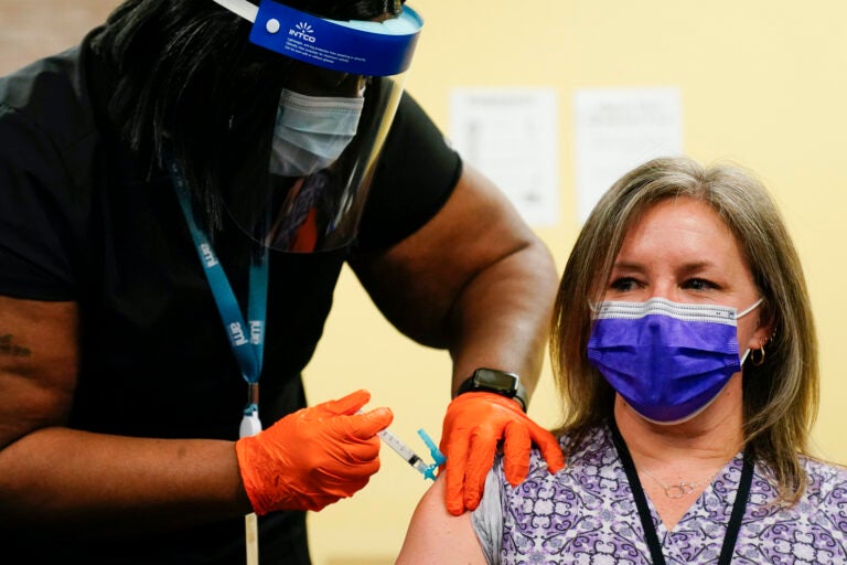 Nurse Monique Bourgeois, left, administers the Johnson & Johnson COVID-19 vaccine to educator Diane Kay at a vaccination site set up setup for teachers and school staff at the Berks County Intermediate Unit in Reading, Pa., Monday, March 15, 2021. (AP Photo/Matt Rourke)