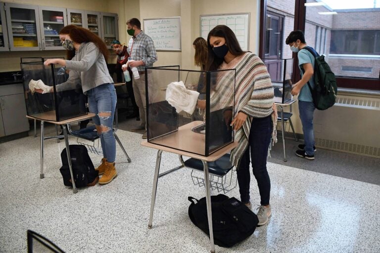In this March 18, 2021, file photo, students in teacher Christopher Duggan's science class clean their work areas at the end of class at Windsor Locks High School in Windsor Locks, Conn. (AP Photo/Jessica Hill)