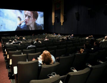 Moviegoers sitting in a socially distant seating arrangement at the AMC Lincoln Square 13 theater