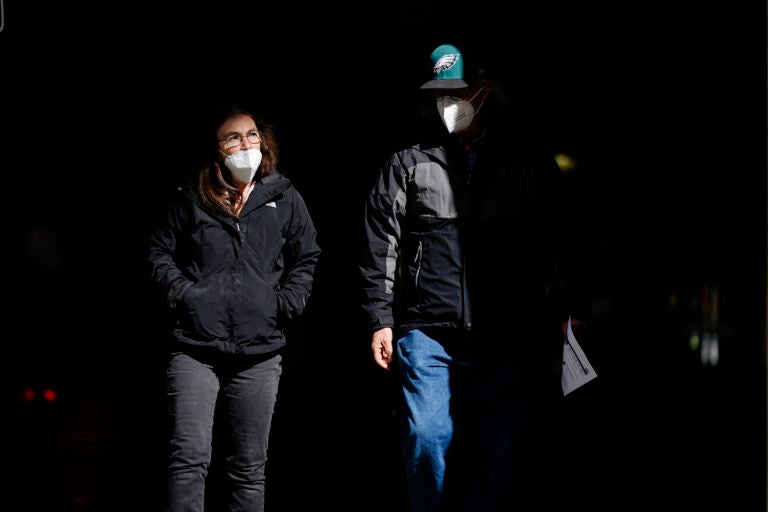 People wearing face masks as a precaution against the coronavirus walk in Philadelphia