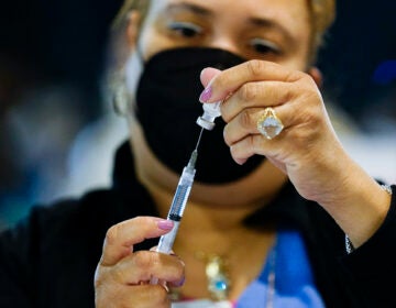 A health worker prepares a dose of the Pfizer COVID-19 vaccine
