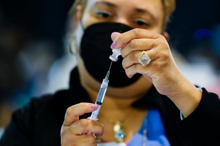 A health worker prepares a dose of the Pfizer COVID-19 vaccine