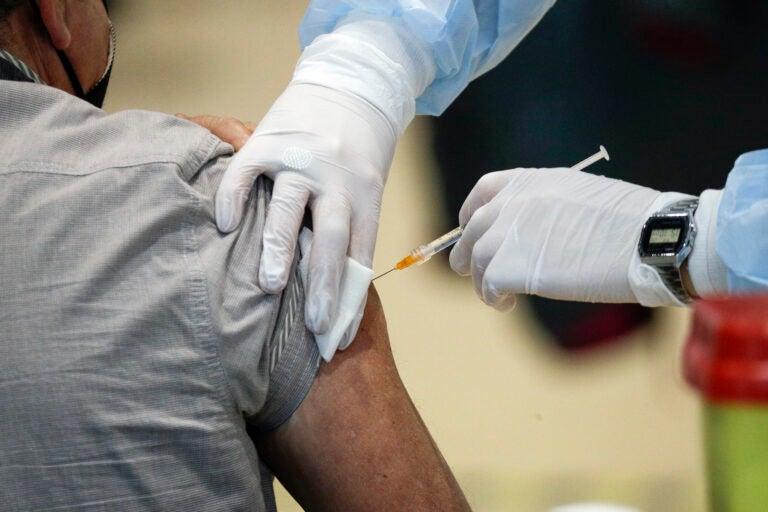 Staff members administer the AstraZeneca vaccine