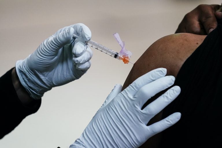 A member of the Philadelphia Fire Department administers the Johnson & Johnson COVID-19 vaccine to a person at a vaccination site setup