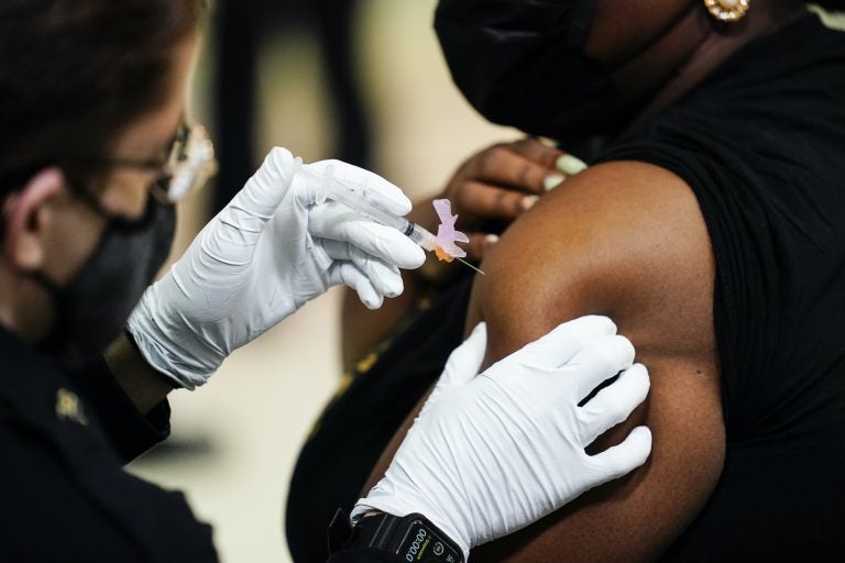 A member of the Philadelphia Fire Department administers the Johnson & Johnson COVID-19 vaccine to a person at a vaccination site setup