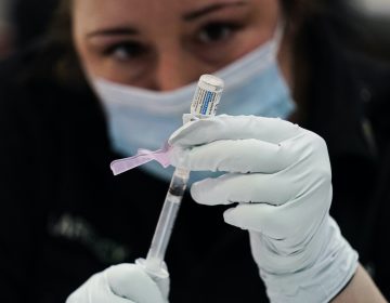 A member of the Philadelphia Fire Department prepares a dose of the Johnson & Johnson COVID-19 vaccine