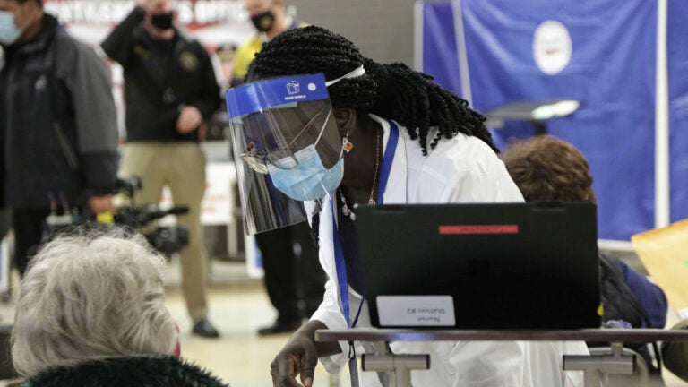 A health worker assists a resident at Passaic County’s vaccination site