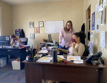 
ALDEA executive director Bridget Cambria reviews work of communications and intake assistant Nathalia Cruz in ALDEA's downtown Reading office. (Anthony Orozco/WITF)