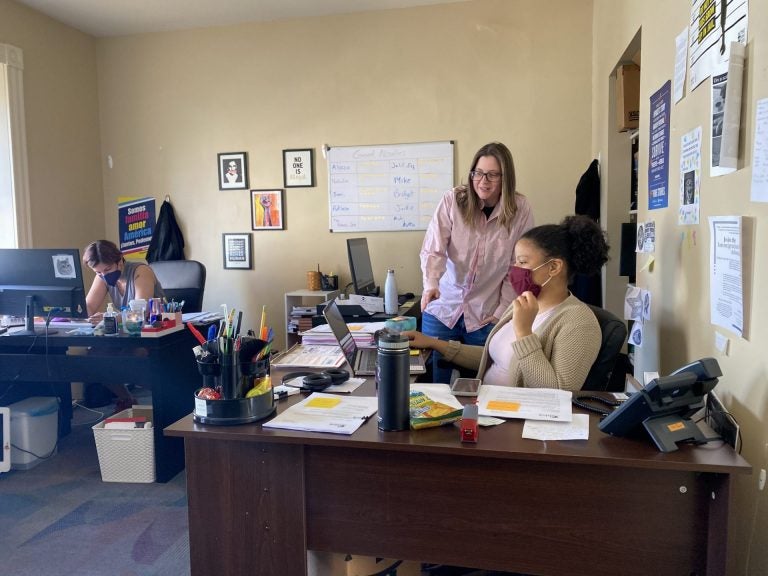 
ALDEA executive director Bridget Cambria reviews work of communications and intake assistant Nathalia Cruz in ALDEA's downtown Reading office. (Anthony Orozco/WITF)