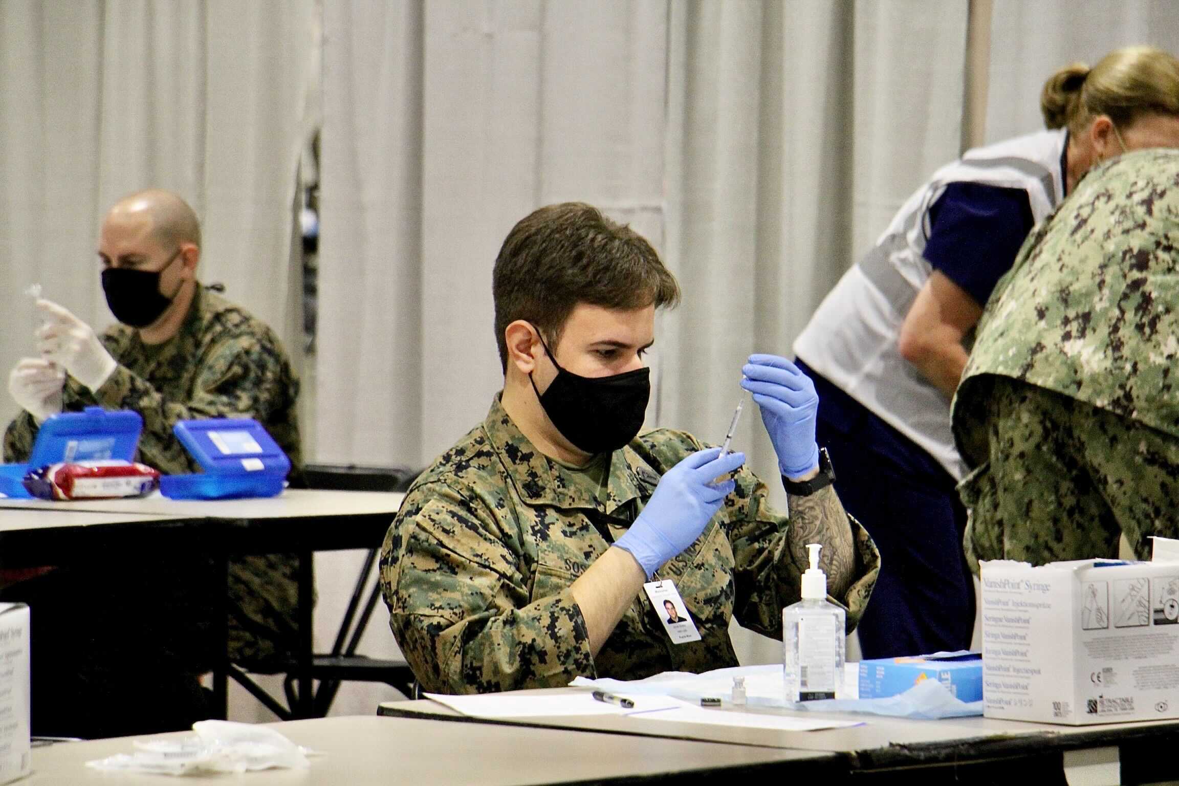 National Guard members fill syringes at the federally-run COVID-19 vaccination site