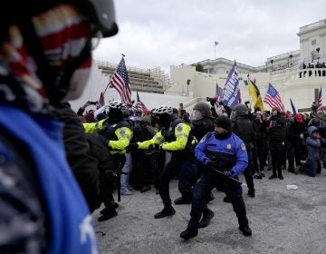 Police officers try to push back pro-Trump insurrectionists trying to break through a police barrier