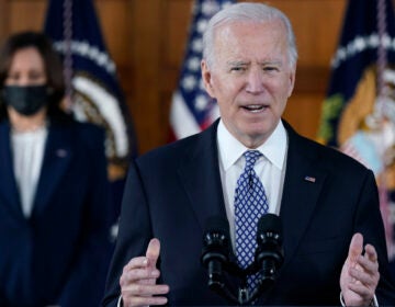 President Biden speaks while Vice President Harris is seen in the background.