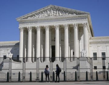 People view the Supreme Court building from behind security fencing on Capitol Hill