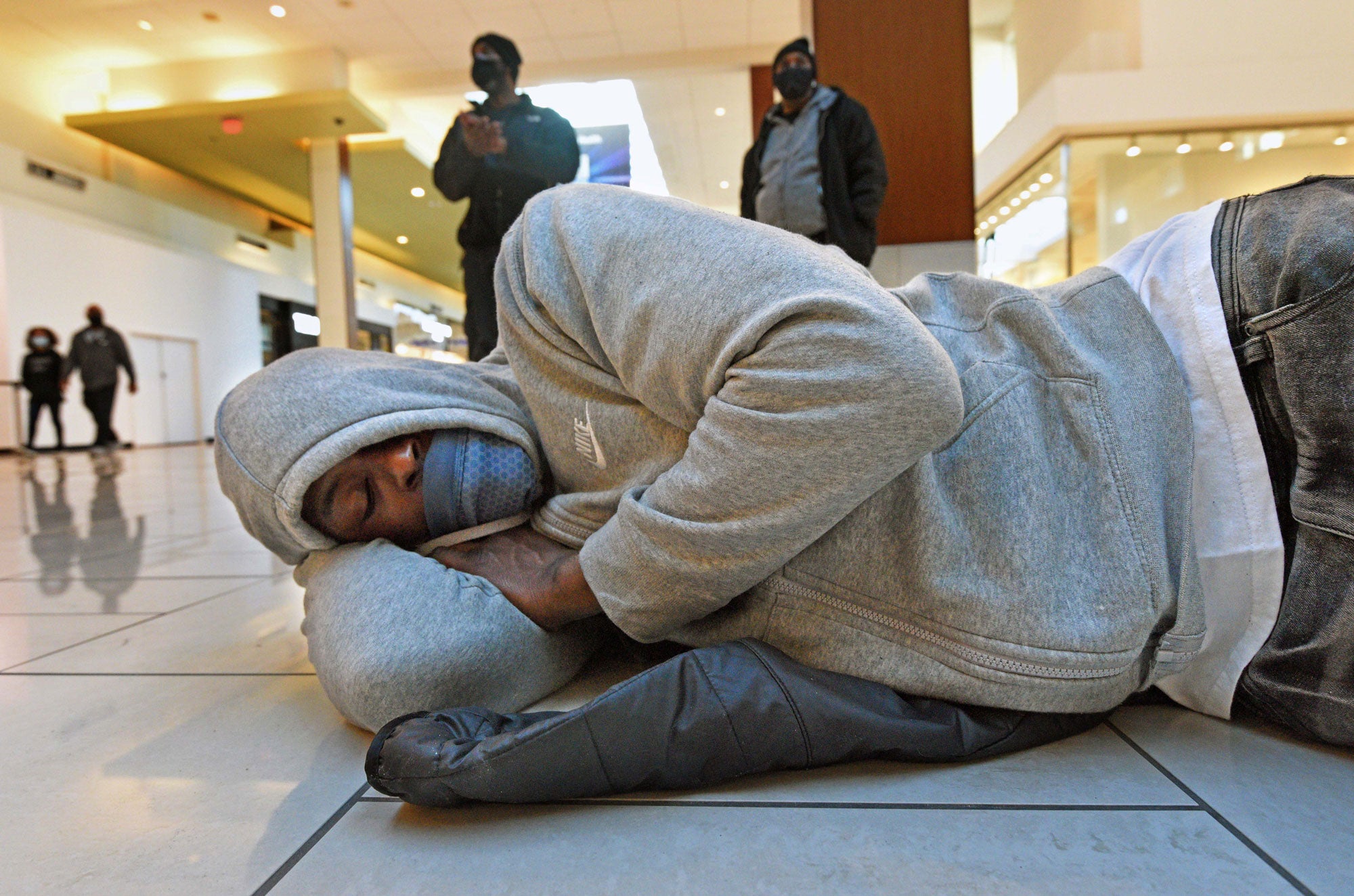 A man naps at Cherry Hill Mall during a demonstration