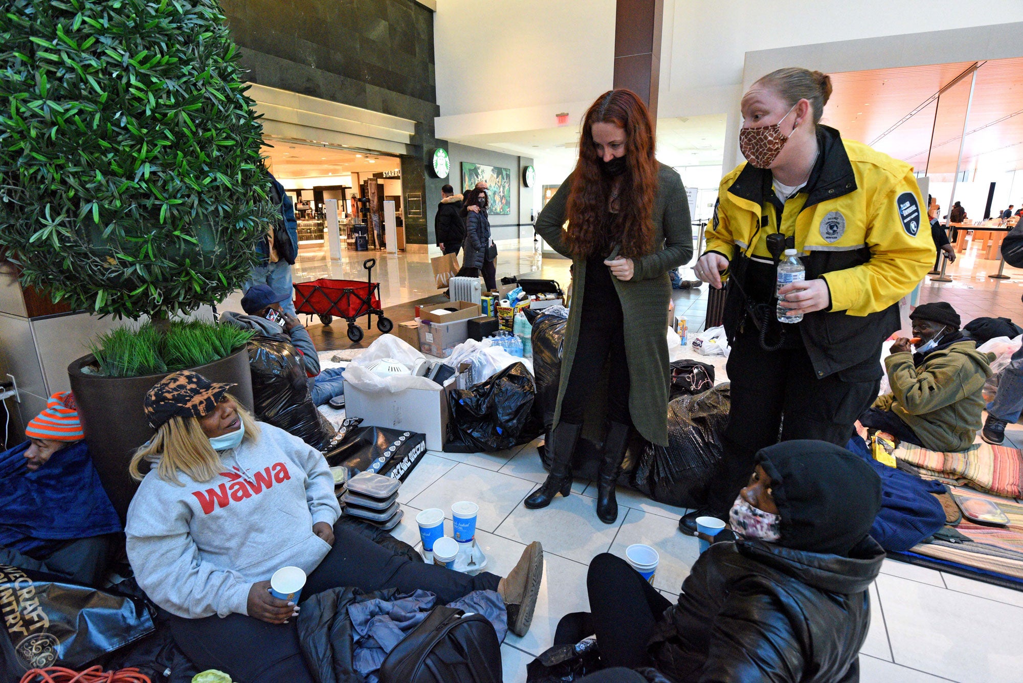 Tawanda Jones (left), Judyann McCarthy (center). and a mall security guard confer during a demonstration