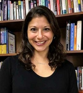 Psychologist Carrie Spindel Bashoff stands in front of a bookcase