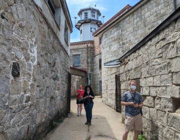 Visitors in the Eastern State Penitentiary courtyard wearing face masks.