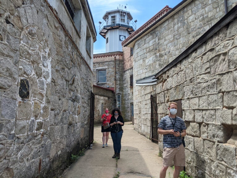 Visitors in the Eastern State Penitentiary courtyard wearing face masks.