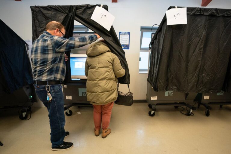 election_ballot_question_SPA_032321 A person enters the voting booth to cast their ballot