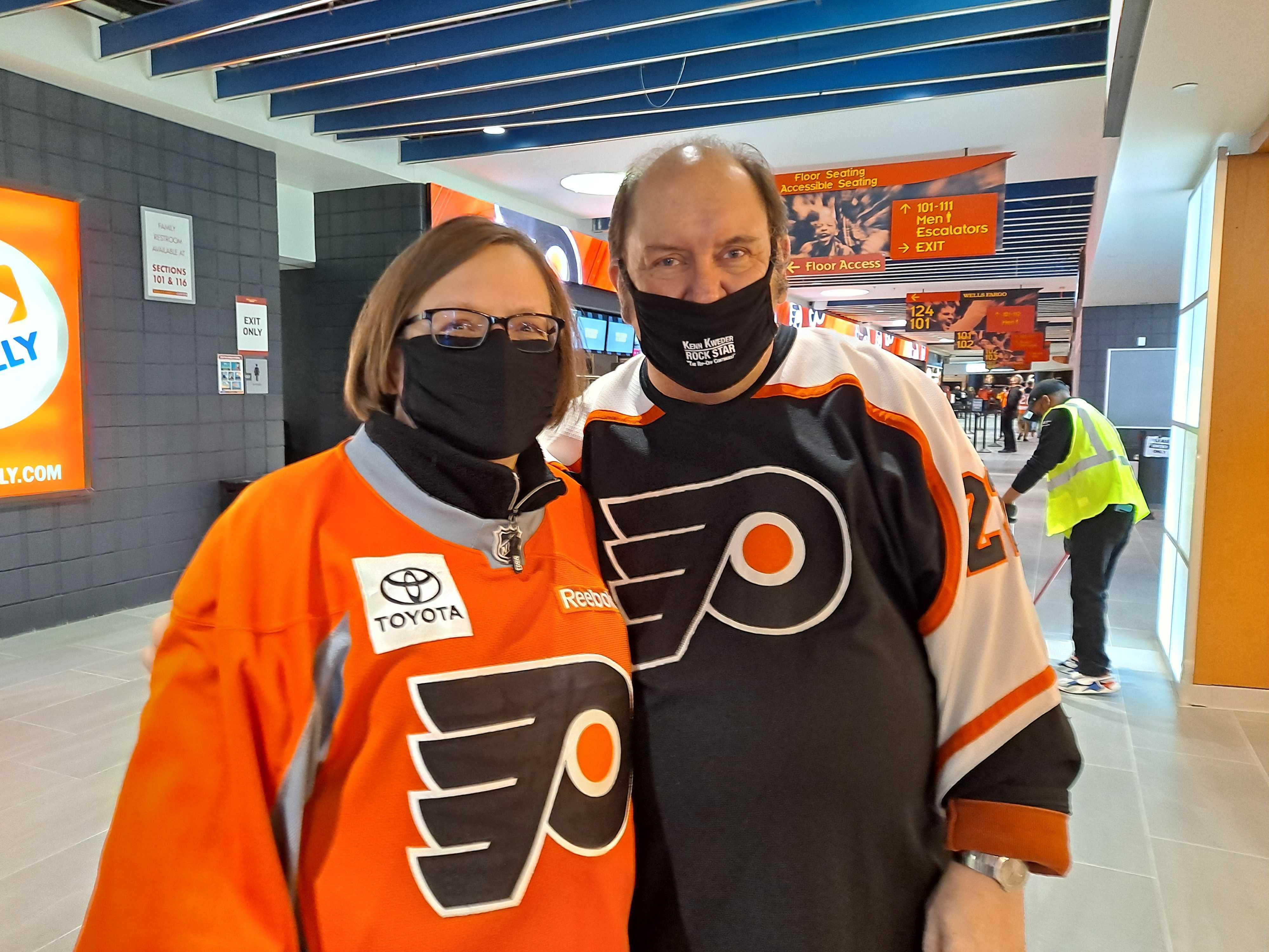 Terry Haas and her husband, wearing Flyers gear inside the Wells Fargo Center