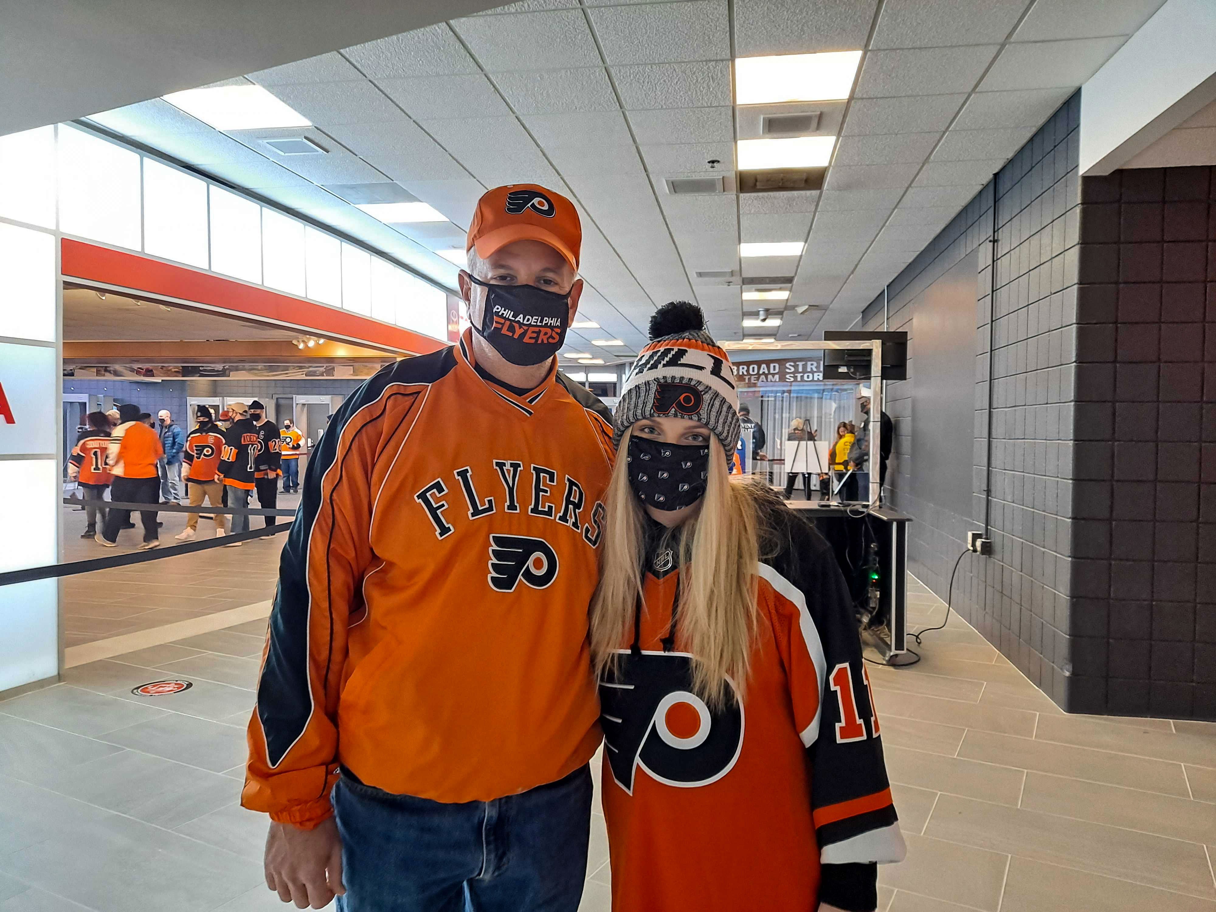 Joe Arnone and his daughter, wearing Flyers gear inside Wells Fargo Center