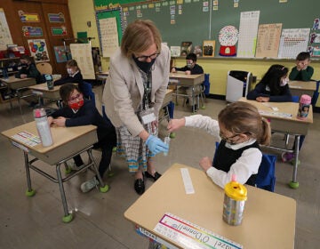 A student gives her coronavirus swab to Helenann Civian