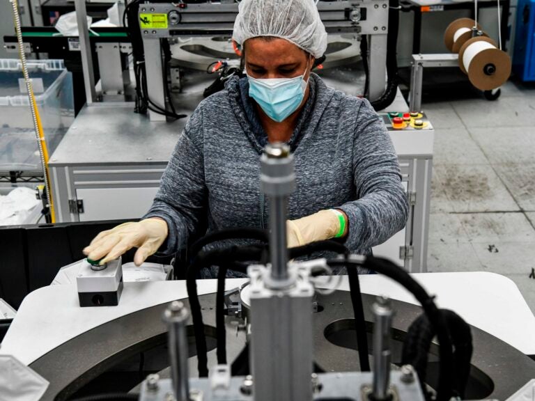 An employee makes respiratory masks in a family-owned medical equipment factory